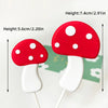 A set of red and white mushroom cake toppers with white stems on wooden sticks.