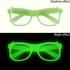 Pair of neon green glow in the dark party glasses shown under daytime and night light conditions.