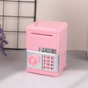 A pink kids mini piggy bank and money box with a silver keypad is shown on a light surface.