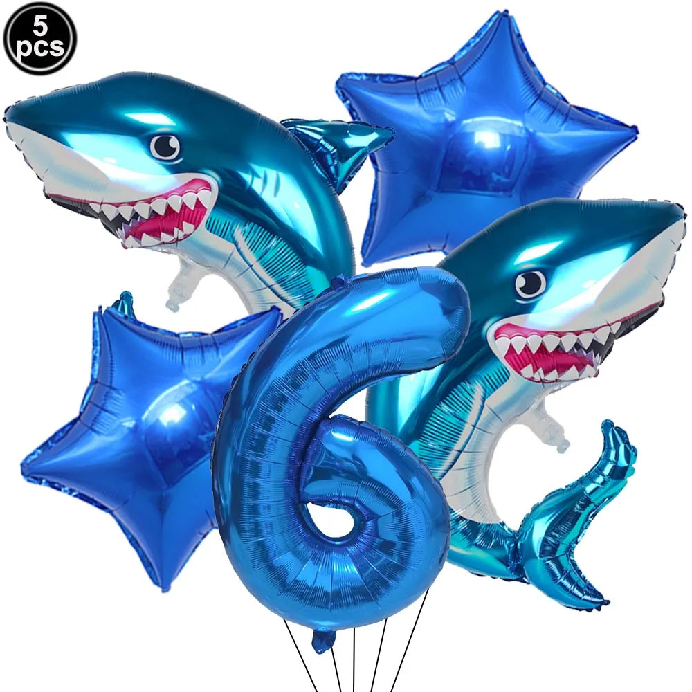A blue shark foil balloon decoration with a toothy smile, used for an ocean-themed party.