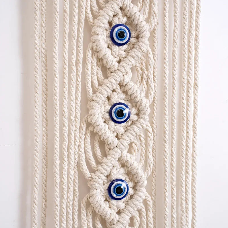 Macrame wall hanging featuring a woven design with multiple blue and white evil eye pendants.