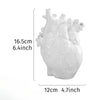 White heart-shaped resin tabletop vase with detailed anatomical features.
