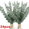 A bundle of artificial eucalyptus stems with realistic green leaves used for home decor and wedding centerpieces.