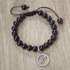 A handmade beaded bracelet with natural black stones and a silver zodiac charm