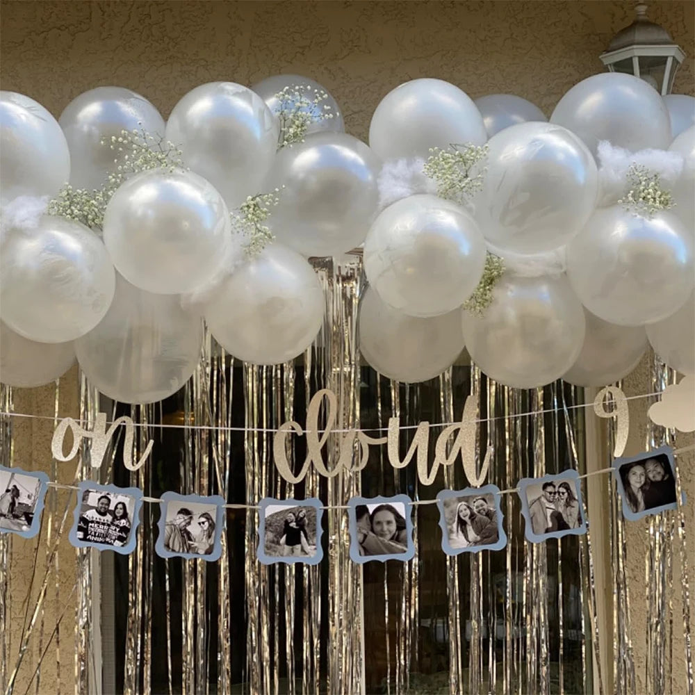 A white pearl latex balloon garland decoration hanging in front of a window.