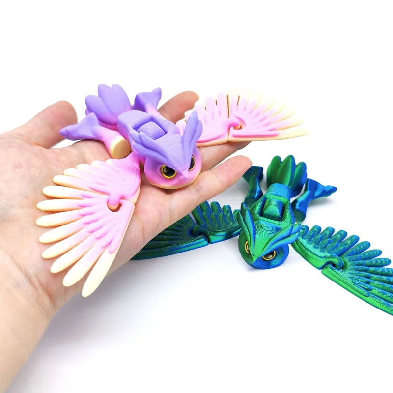 Hand holding a purple and pink articulated 3D printed owl figurine for desk decor.