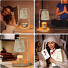 A woman holds an adjustable electric candle warmer lamp with a glass shade and a yellow candle in a cozy indoor setting.