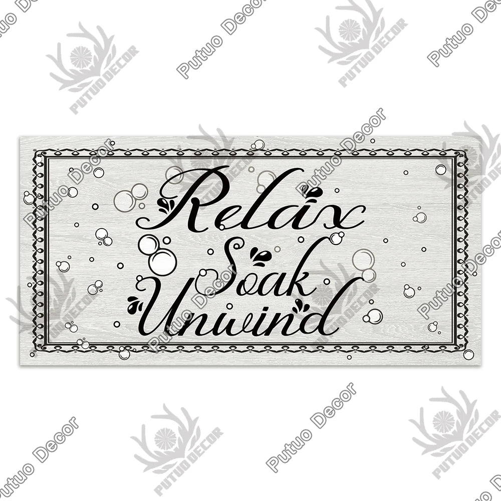 Rustic wooden toilet wall sign with the text Relax Soak Unwind carved into the wood.