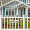 White picket fence in front of a blue and gray house with a white porch and window.