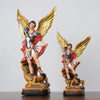 A resin statue of Saint Michael the Archangel with golden wings and armor.