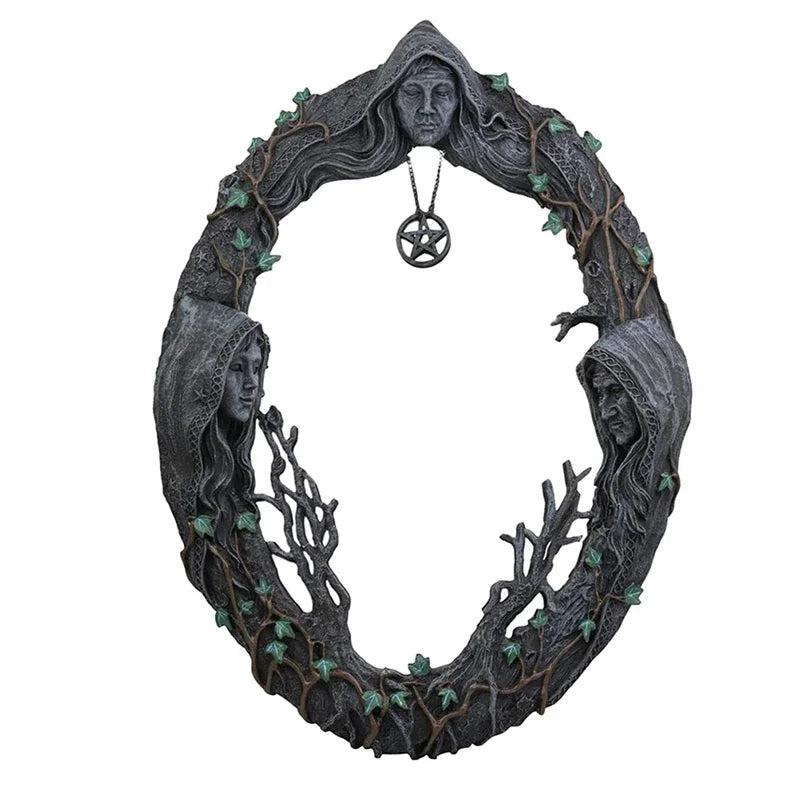 A dark, intricate wall hanging mirror wreath made of branches and leaves, featuring a central pentagram amulet.