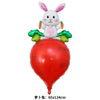 A white cartoon bunny foil balloon sitting on a large red radish shaped balloon.