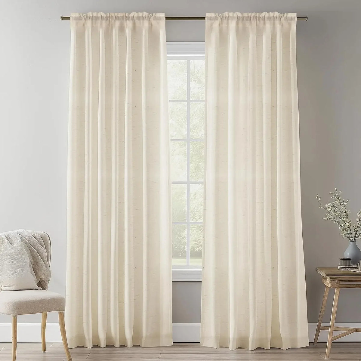 Cream natural linen sheer curtains with rod pocket hanging in a bright room.