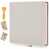 A grey linen scrapbook photo album with a spine showing red and white pages and an orange glue stick and colorful adhesive st