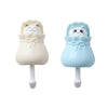 A pair of light beige and light blue cartoon cat wall hooks for organization.