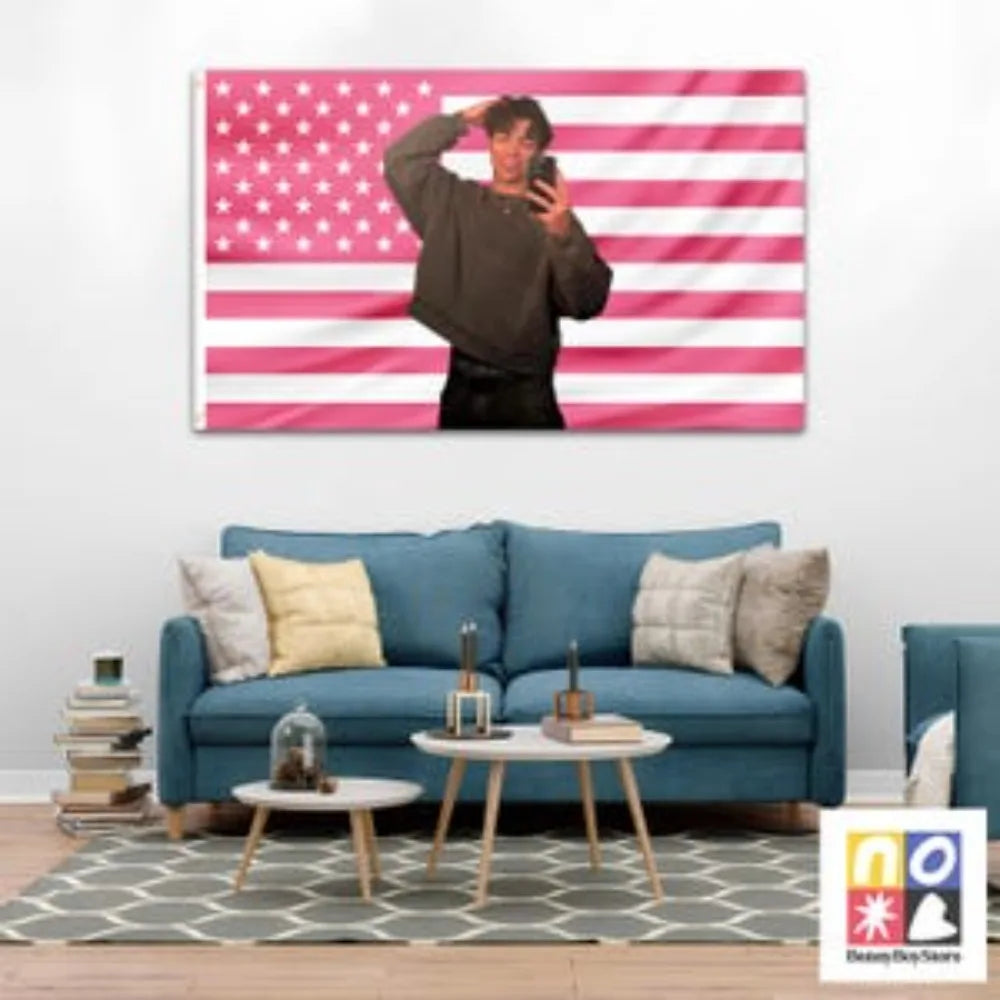 A wall tapestry featuring a pink and white striped flag with a person posing in front of it.