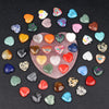 A collection of heart-shaped amethyst crystal stones in various colors and shades scattered on a dark surface.