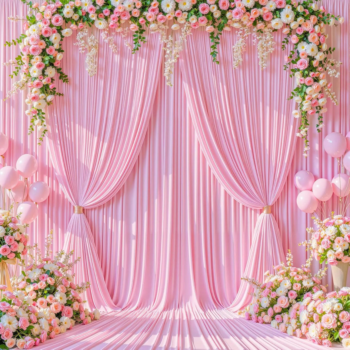 A pink fabric backdrop with draped curtains and floral garlands, set up for an event.