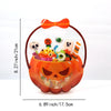 An orange Halloween pumpkin shaped bag filled with various witch-themed treats and a bow.