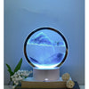 A 3D Quicksand LED table lamp with a blue color-changing light illuminating a mountain landscape.