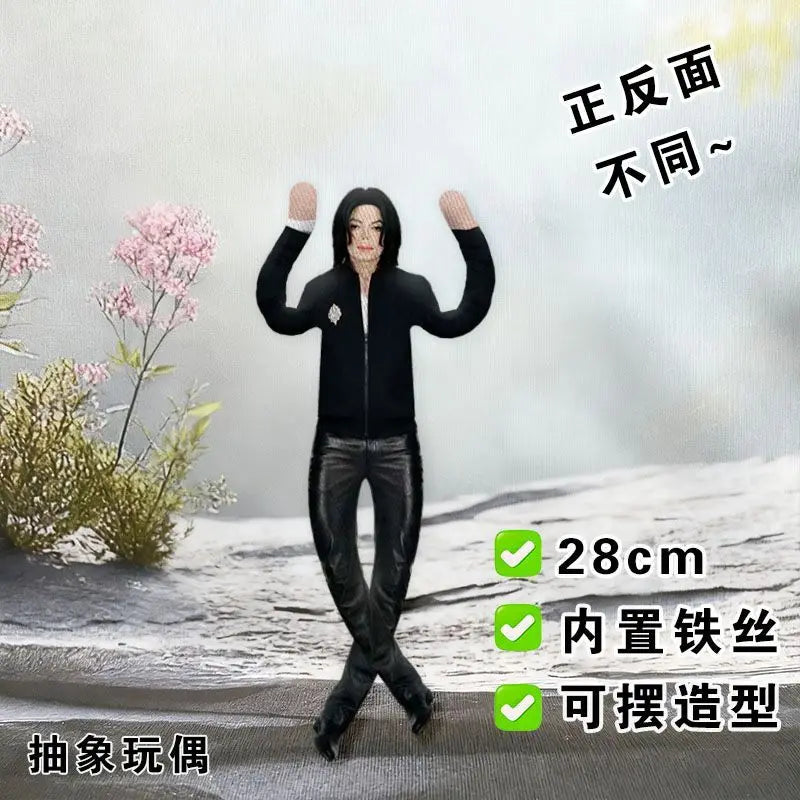 A black plush doll resembling Michael Jackson in a standing pose, displayed against a snowy background.