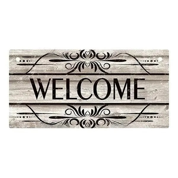 A rustic wooden hanging sign with the word WELCOME carved into the wood and decorated with ornamental lines.