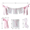 A decorative birthday garland for a first birthday featuring pink and white letters.