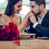 A couple looking at each other while holding a heart-shaped acrylic keepsake that says I love you