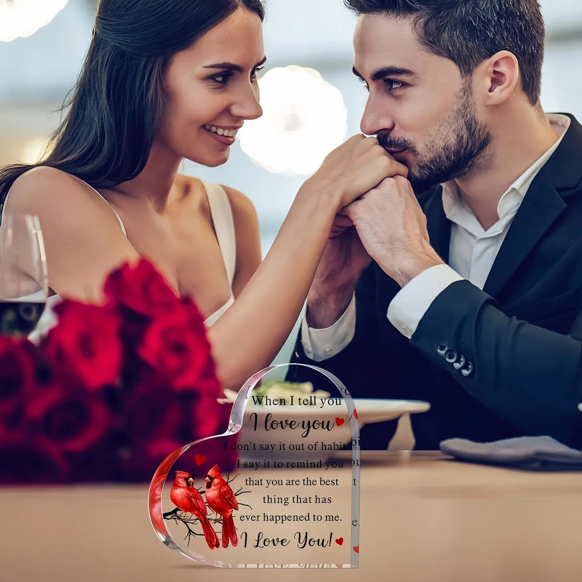 A couple looking at each other while holding a heart-shaped acrylic keepsake that says I love you