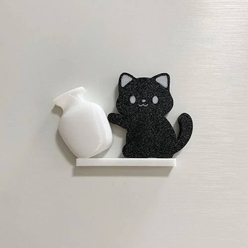 A black glitter cat figurine and a white acrylic bottle are displayed on a white magnetic strip.