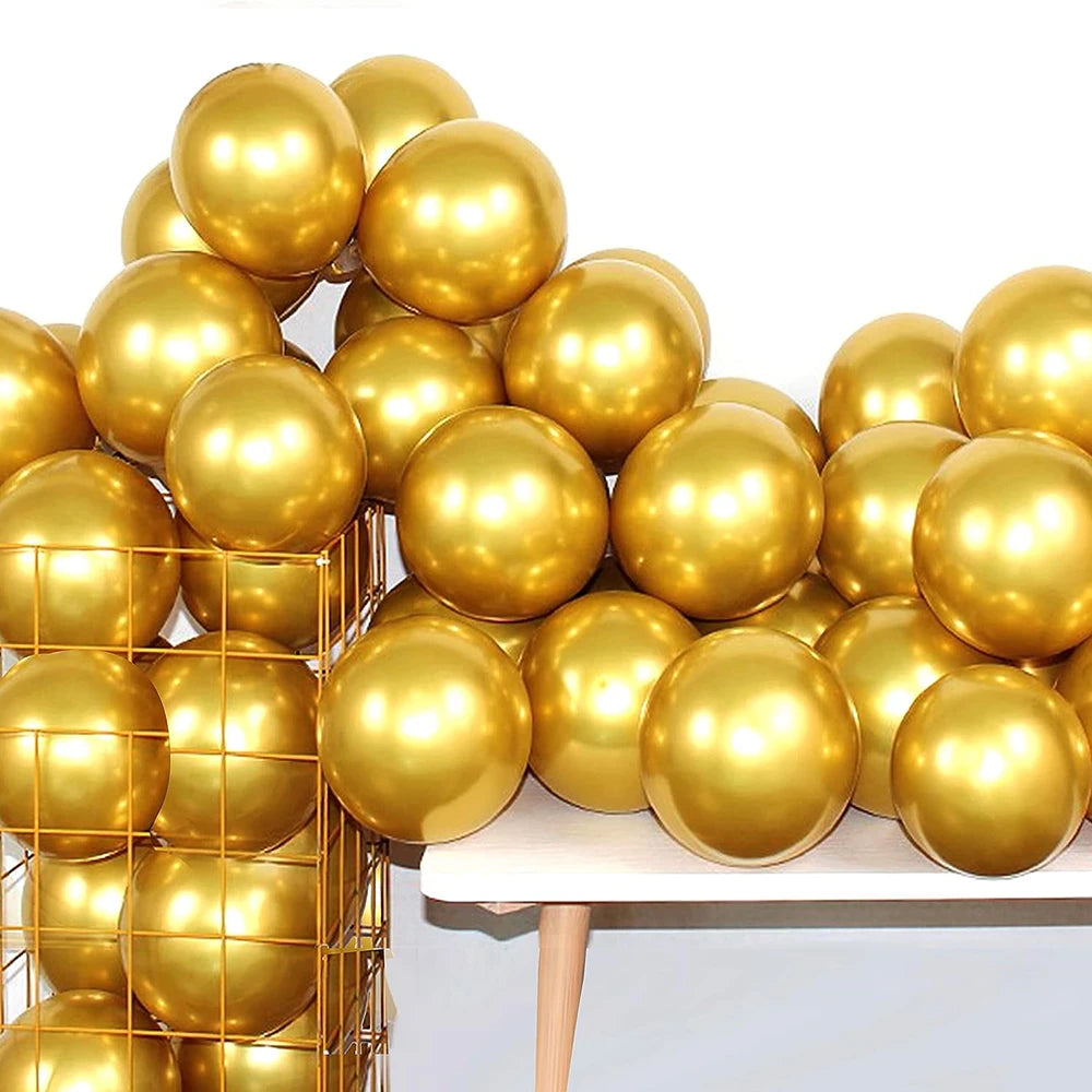 A cluster of metallic gold balloons piled on a white table for party decorations.