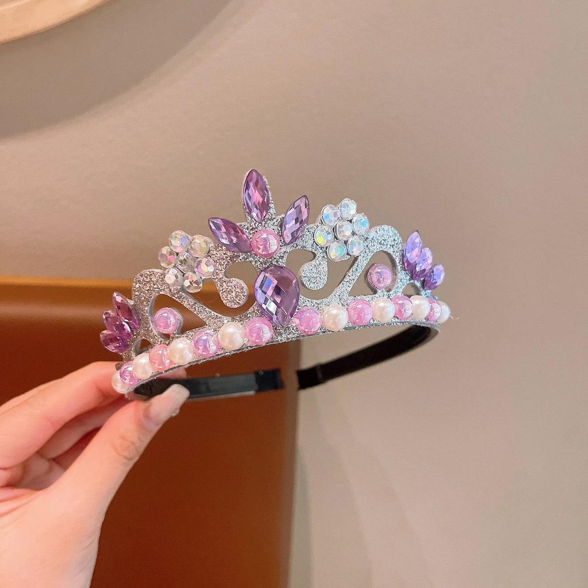 A sparkling crown headpiece set featuring purple and pink iridescent crystals and pearls.