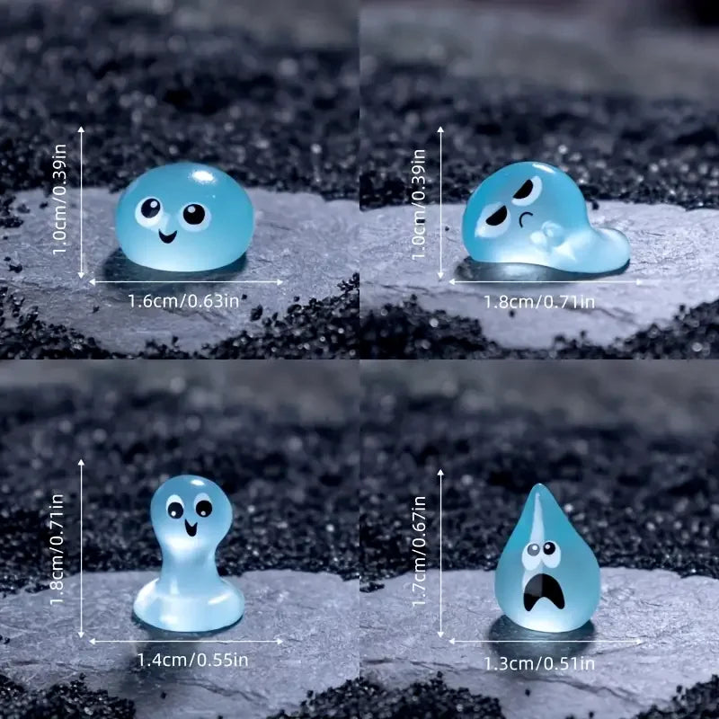 A set of eight glow-in-the-dark resin fairy water droplet figurines in various shapes and sizes resting on a dark surface.