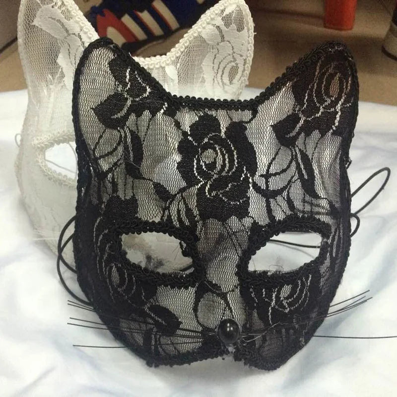 Black lace half-face mask with intricate floral patterns displayed on a white surface.