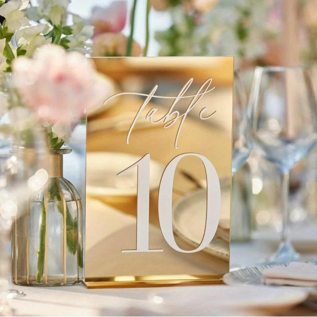 Elegant gold plated mirrored acrylic table numbers with the number 10 on a wooden surface.