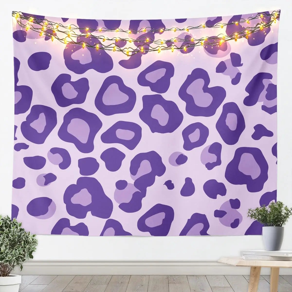 A purple leopard print tapestry wall hanging decorated with warm string lights.