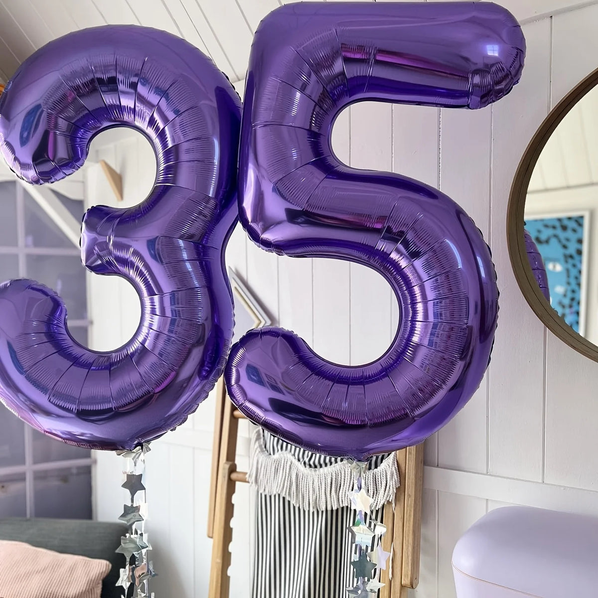 Purple foil number balloon shaped like 35 hanging in a room