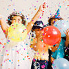 Children joyfully throw multicolor paper confetti into the air during a celebration