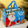 A blue tote bag featuring a festive Christmas design with a smiling Santa face and green foliage.
