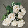 A bouquet of white silk peonies with green leaves and small white filler flowers.