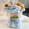 A handmade crochet flower bouquet featuring various textured flowers and small animal figures in pastel blue and yellow.