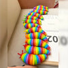 A colorful, flexible fidget slug toy made of silicone in a rainbow gradient, arranged in a curved line.