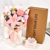 A handmade crochet tulip bouquet with pink and white flowers is displayed next to a brown box labeled Light Your Life.