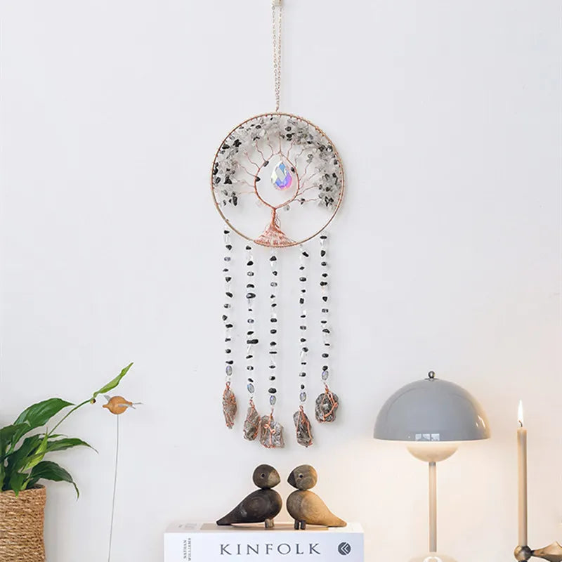 A hanging crystal tree of life sun catcher wall decor with a circular frame and dangling beads.