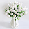 A bouquet of white artificial tulip flowers arranged in a white vase for home decor.