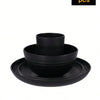 A set of four black reusable plastic tableware items including a bowl and plates.