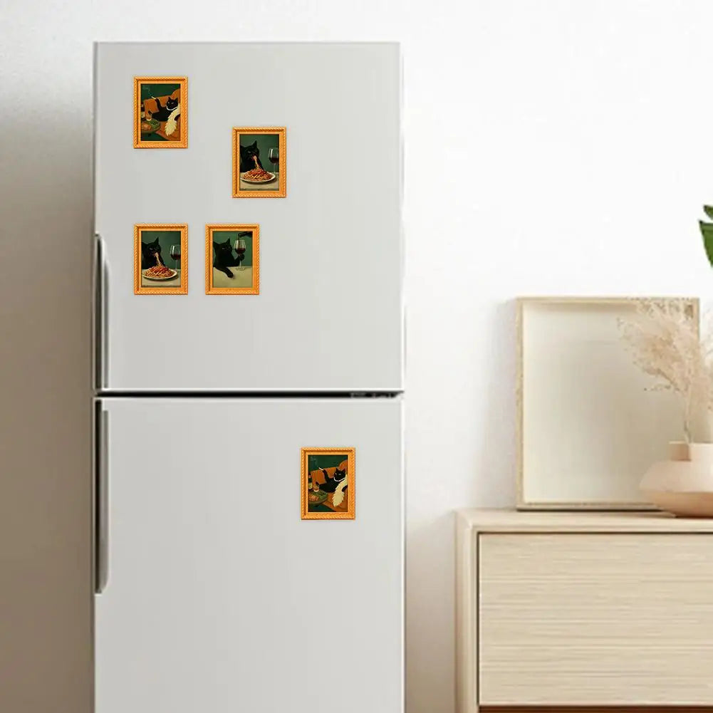 A white refrigerator door decorated with four vintage style wooden fridge magnets featuring playful black cat art.