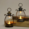 A vintage battery-powered desk lamp with an antique metal finish and clear glass bulb resting on a wooden surface.