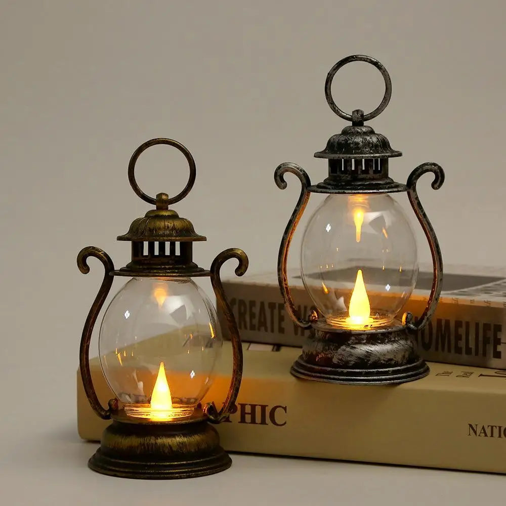 A vintage battery-powered desk lamp with an antique metal finish and clear glass bulb resting on a wooden surface.