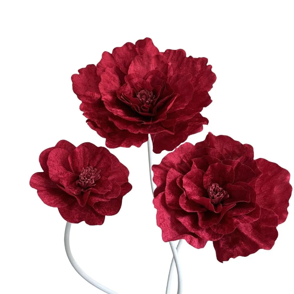 A cluster of deep red velvet artificial peony flowers on a white stem.